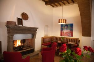 a living room with a fireplace and red chairs at Sant'Angelo 42 in Orvieto