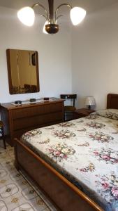 a bedroom with a bed with a dresser and a mirror at Villa Bontempo in Gleris