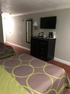 a hotel room with a bed and a flat screen tv at Super 8 by Wyndham Inglewood/LAX/LA Airport in Inglewood