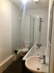 a white bathroom with a sink and a toilet at Smart central apartment, 5 mins from centre in Cardiff