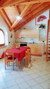 cocina con mesa y mantel rojo en Casa Bamby, en Cogolo