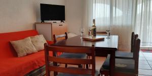 a living room with a table with wine glasses and a couch at Apartments Stefan Cesarica in Cesarica