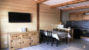 a kitchen and dining room with a table and a television at STUDIO 4 pers, Cœur station, Proche pistes in Les Deux Alpes