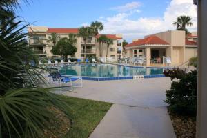 una piscina en un complejo con sillas y un edificio en Ocean Village Club C15, en St. Augustine