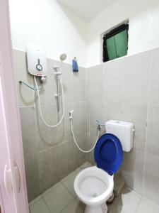 a bathroom with a toilet with a blue seat at Lodge88 ( l l ) in Ranau