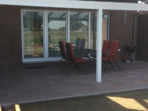 a patio with a table and chairs and a grill at Ferienhaus Landblick in Geldern