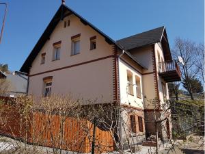 een wit huis met een hek ervoor bij Apartament Grota in Szklarska Poręba