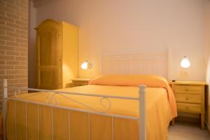 a bedroom with a bed with an orange blanket and a dresser at Chibao in Ragusa