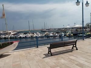 a bench sitting next to a marina with boats at Appartamento Paola marina di Ostuni in Villanova di Ostuni