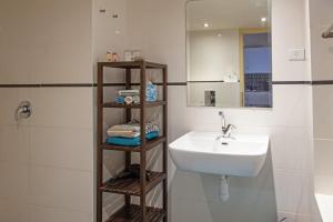ein weißes Badezimmer mit einem Waschbecken und einem Spiegel in der Unterkunft Krivine B&B in Midreshet Ben Gurion