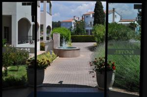 a view of a garden from a window of a building at Hotel Flores in Poreč