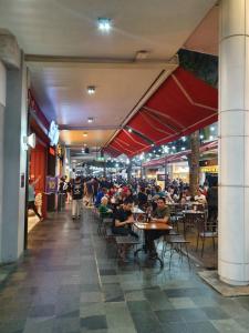 a group of people sitting at tables in a restaurant at M-Town Residence 1 BR Comfy Tangerang in Tangerang