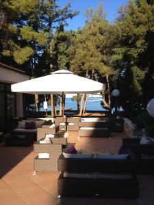 a large white umbrella sitting on a patio near the water at Hotel Flores in Poreč