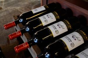 a bunch of wine bottles on a wooden shelf at RINCON DE LOS MATREROS in Isla Patrulla