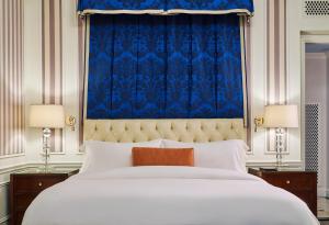 a bedroom with a large bed with a blue curtain at 5th & 55th Residence Club in New York