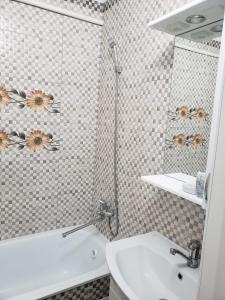 a bathroom with a tub and a sink and a mirror at Apartament Chisinau str.Cuza Voda in Chişinău