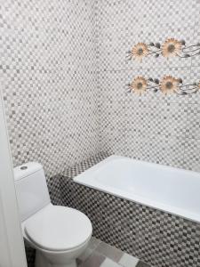 La salle de bains est pourvue de toilettes blanches et d'une baignoire. dans l'établissement Apartament Chisinau str.Cuza Voda, à Chişinău