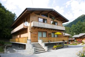a wooden house with a staircase in front of it at Chalet Marmotte 1 in Morzine