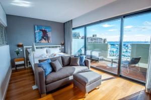 a living room with a couch and a large window at Pestana Cidadela Cascais - Pousada & Art District in Cascais