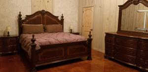 um quarto com uma grande cama de madeira e uma cómoda em Breezy Hills Cottages - Moonlight Cottage em Fredericksburg