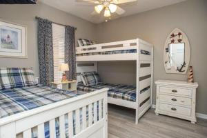 een slaapkamer met 2 stapelbedden en een spiegel bij Seaside at Anastasia C202 in St. Augustine