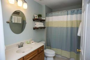 een badkamer met een toilet, een wastafel en een spiegel bij Seaside at Anastasia C202 in St. Augustine +17 foto's