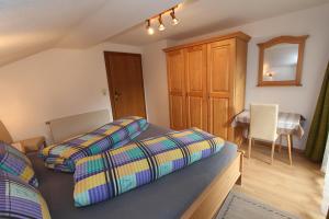 1 Schlafzimmer mit 2 Betten, einem Tisch und einem Schreibtisch in der Unterkunft Gästehaus Hauser in Hainzenberg