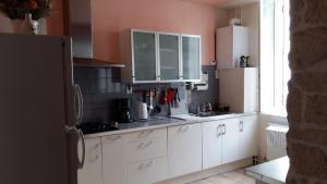 a kitchen with white cabinets and a white refrigerator at Gîte MarieJo in Villandraut