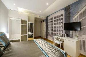 1 dormitorio con 1 cama, escritorio y TV en B&B Quarto Novo Suite en Foggia