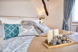 a bedroom with a bed with two candles on it at Historisches Gästehaus Au Faucon in Wissembourg