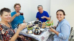 a group of people sitting around a table with food at Rudakiy Guest House in Bukhara