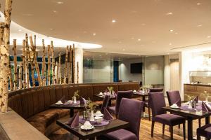 a restaurant with tables and chairs and a couch at Business Class Hotel Ebersberg in Ebersberg