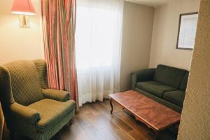a living room with two chairs and a coffee table at Hotel La Joya Tulancingo in Tulancingo