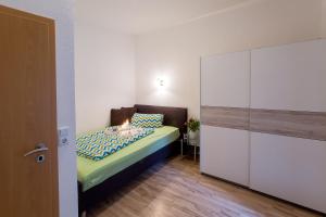 Dormitorio pequeño con cama y armario en Neanderappartement, en Mettmann