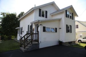 a white house with black windows and a porch at Charming Home Near Ski Areas in Rumford