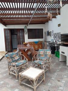 a patio with a table and chairs in a kitchen at Hostel Bike Point Caraguatatuba in Caraguatatuba
