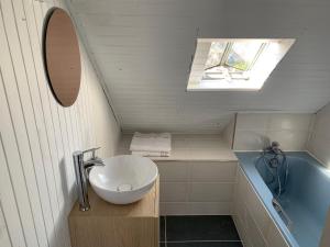 a bathroom with a sink and a bath tub at Jolie maison au port de l’Ile Tudy in Île-Tudy