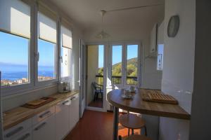 アジャクシオにあるAppartement vue merの窓と景色を望むテーブル付きのキッチンが備わります。