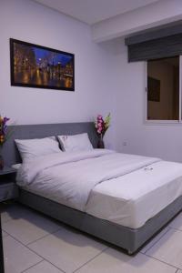 a bedroom with a large bed with white sheets at Residence Achomoukhe in Laayoune