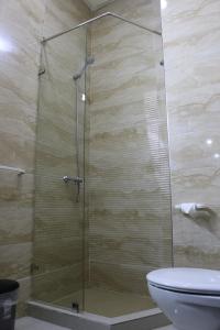 a glass shower in a bathroom with a toilet at Residence Achomoukhe in Laayoune