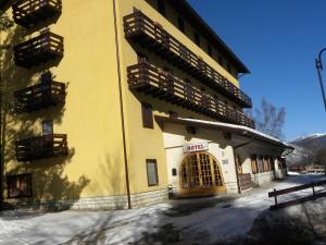 a yellow building with wooden balconies on the side of it at Life Hotels Des Alpes in Folgaria