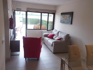 a living room with a couch and a glass table at Apartamentos Borizu Playa in Barro de Llanes