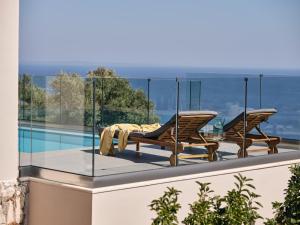 a balcony with two chairs and a table on a roof at Thea lux natur villa in Koríthion
