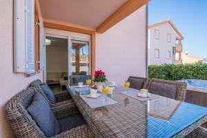 a patio with a table and chairs on a balcony at Apartment M&M Klimno in Klimno
