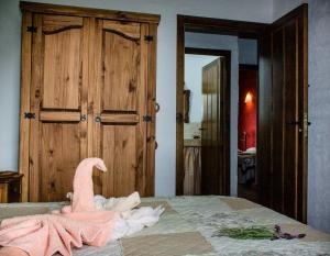 - une serviette rose assise au-dessus du lit dans l'établissement Mirador de Fuentes, à Fuentes de León