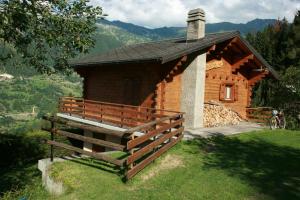 a small wooden cabin with a fence in front of it at Chalet Lé Fèrtin in La Tzoumaz