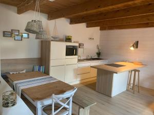 a kitchen with a wooden table and a kitchen with a counter at Jolie maison au port de l’Ile Tudy in Île-Tudy