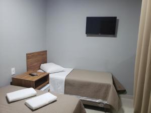 HOTEL UMUARAMA Aparecida SP tesisinde bir odada yatak veya yataklar