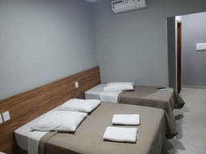 HOTEL UMUARAMA Aparecida SP tesisinde bir odada yatak veya yataklar