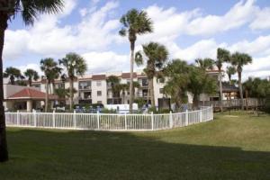 einen weißen Zaun in einem Park mit Palmen in der Unterkunft Ocean Village Club O18 in St. Augustine